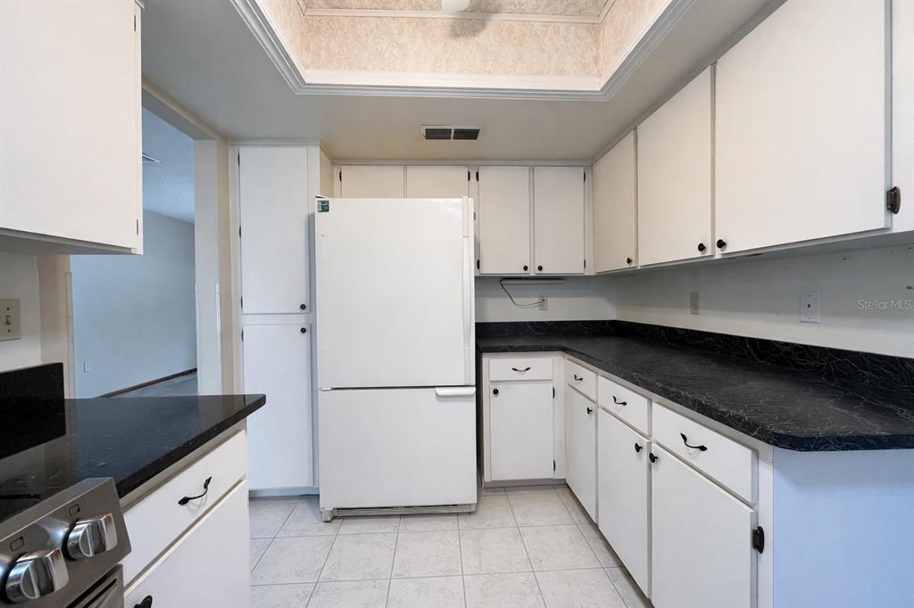 11268 Southwest 75th Terrace Ocala, FL 34476 - Photo 22 of 32 a kitchen with granite countertop white cabinets and white appliances