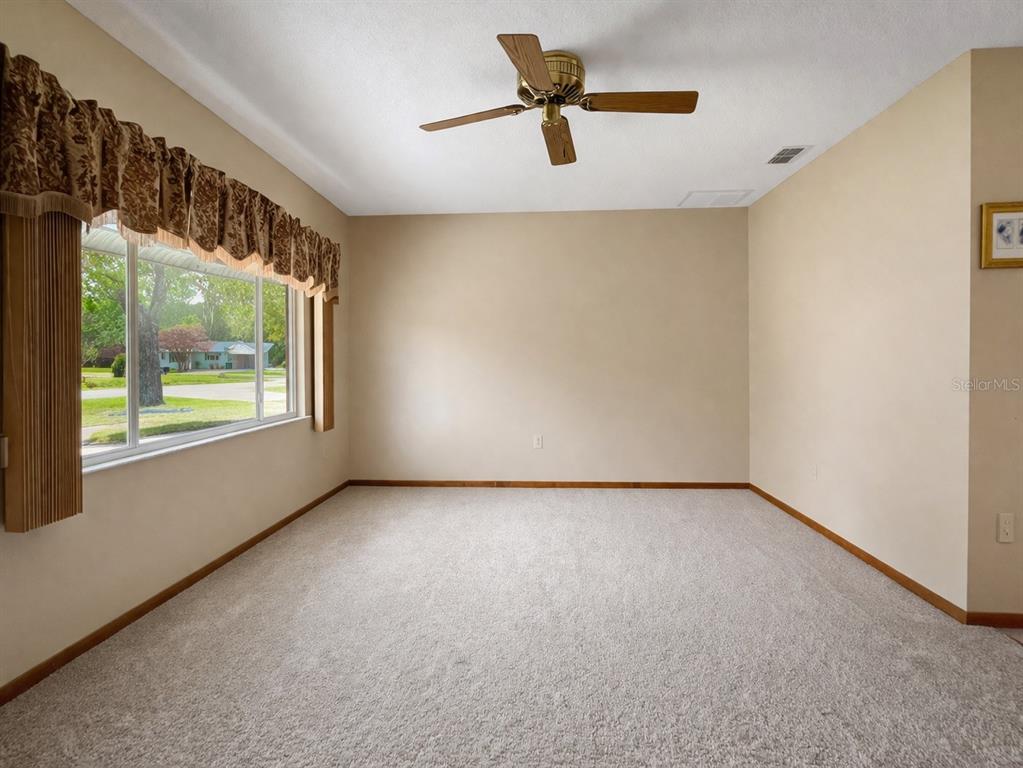 11268 Southwest 75th Terrace Ocala, FL 34476 - Photo 5 of 32 an empty room with windows and fan