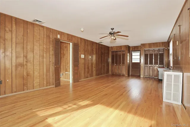 a view of a livingroom with wooden floor and a ceiling fan