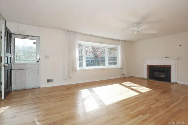 an empty room with windows and fireplace