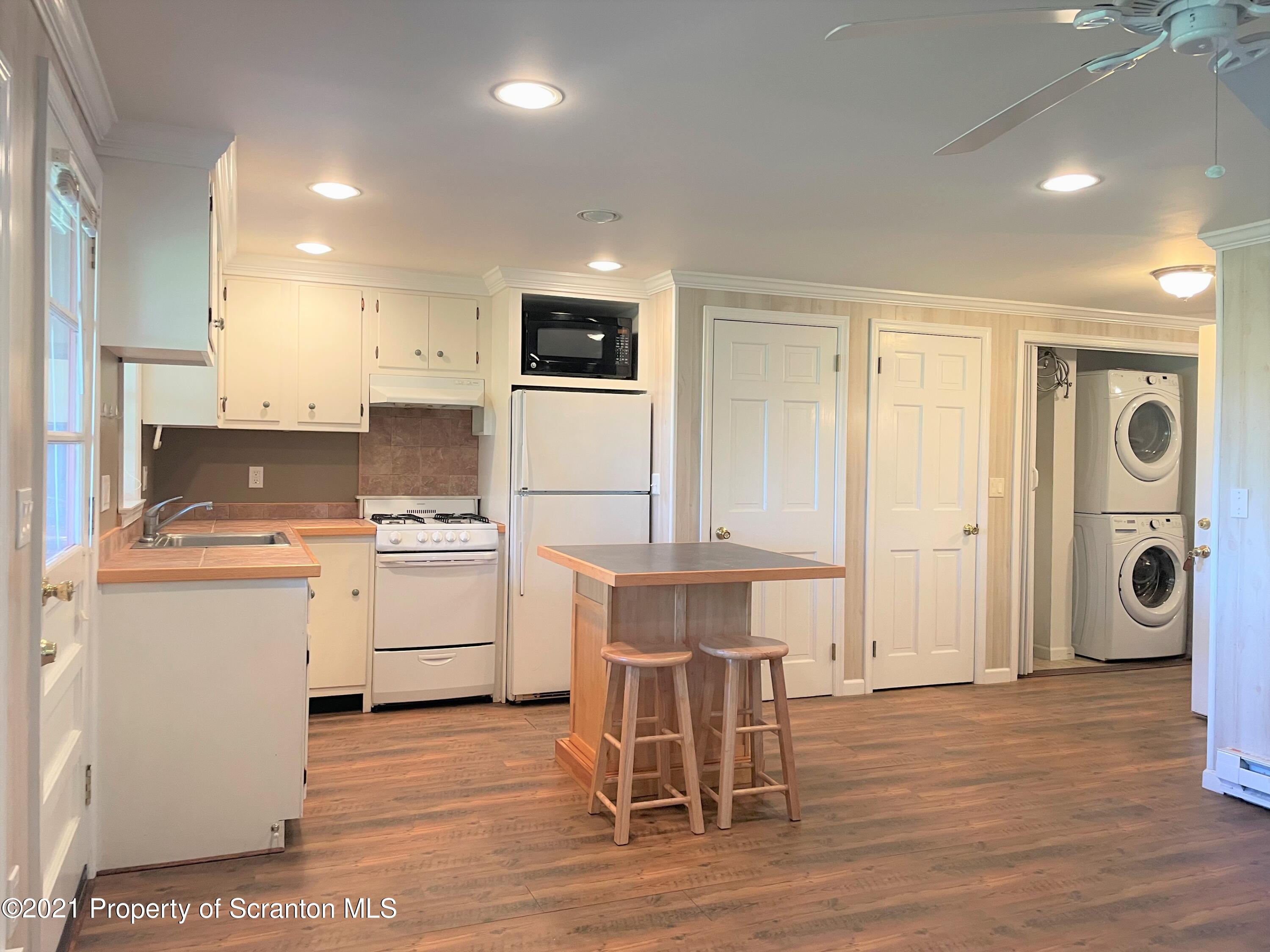 705-771 Hunter Road Springville, PA 18844 - Photo 26 of 62 a kitchen with a refrigerator a stove cabinets and wooden floor