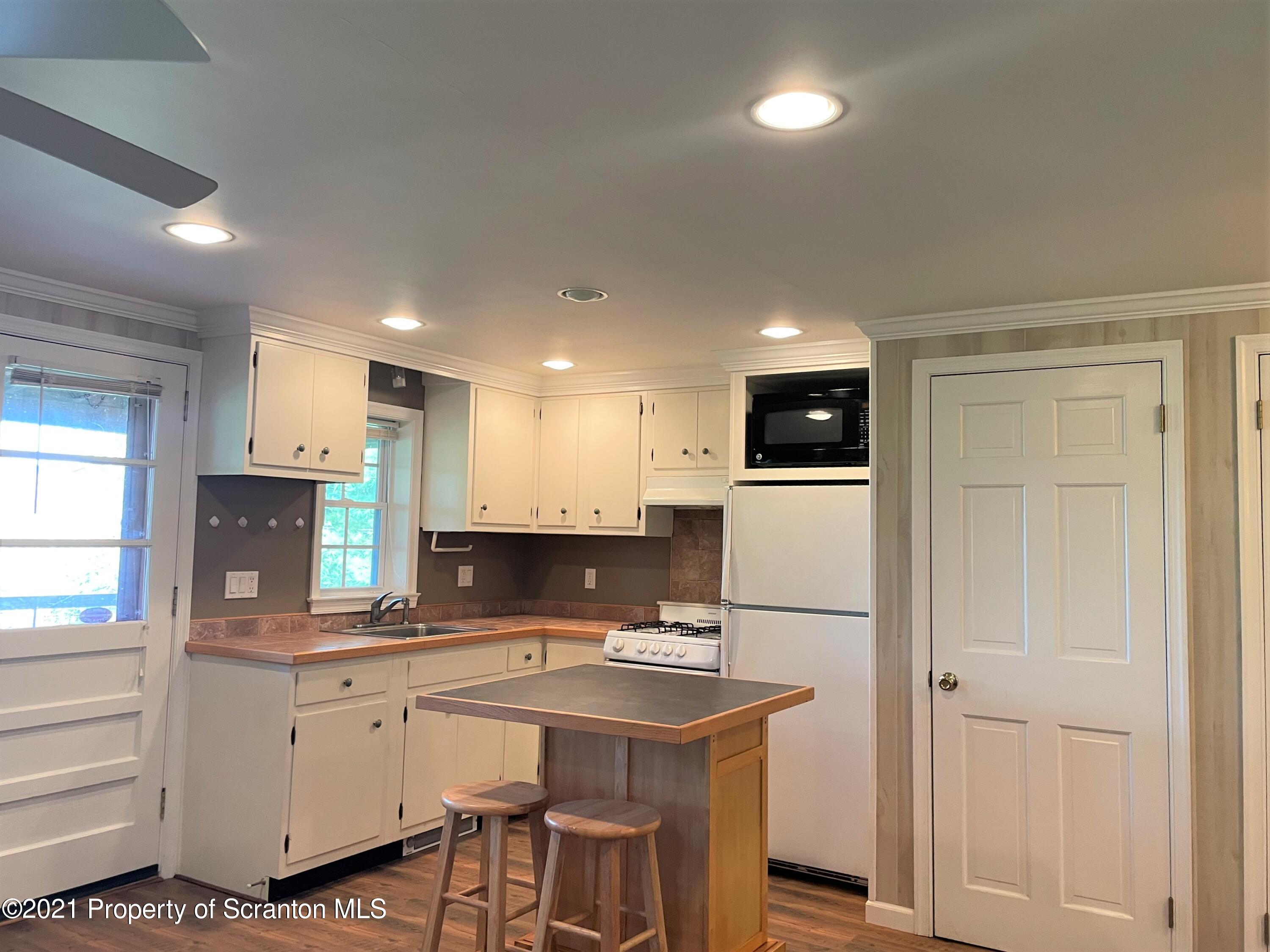 705-771 Hunter Road Springville, PA 18844 - Photo 28 of 62 a kitchen with white cabinets and refrigerator