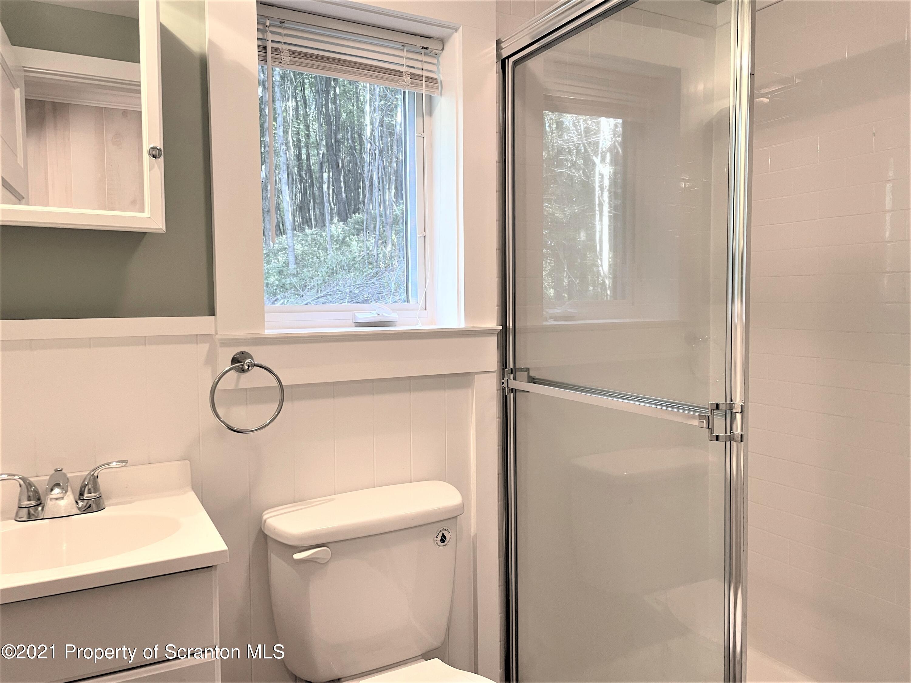 705-771 Hunter Road Springville, PA 18844 - Photo 32 of 62 a bathroom with a toilet a sink and a window