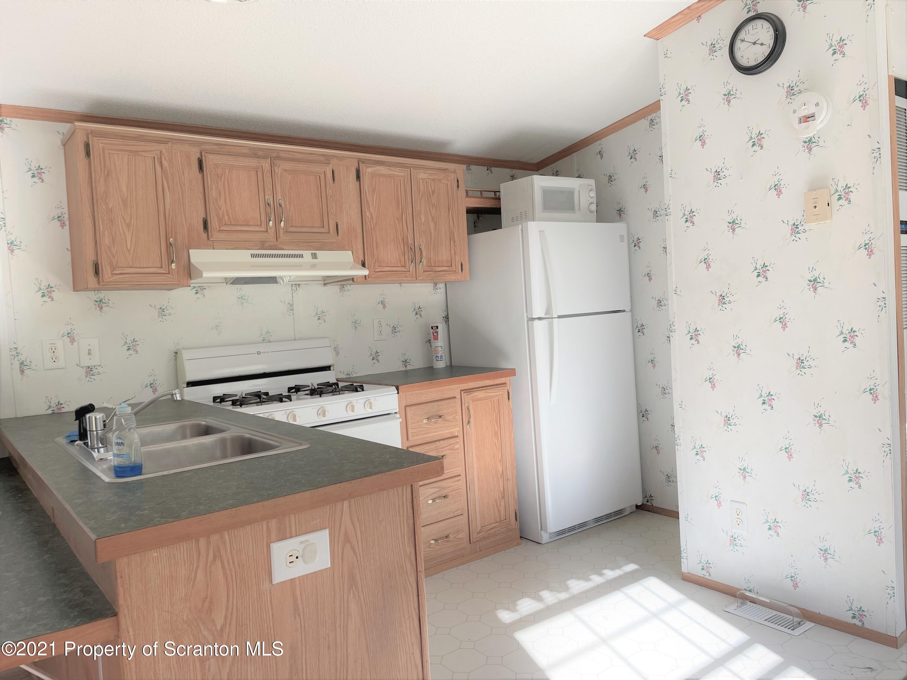 705-771 Hunter Road Springville, PA 18844 - Photo 50 of 62 a kitchen with a stove a refrigerator and a sink
