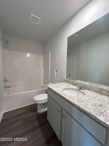 a bathroom with a granite countertop sink toilet and bathtub