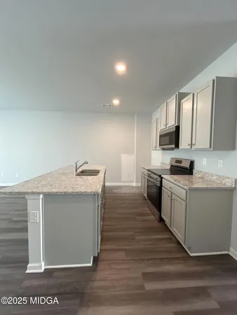 a kitchen with granite countertop a sink and a stove top oven