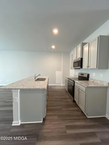 a kitchen with granite countertop a sink and a stove top oven