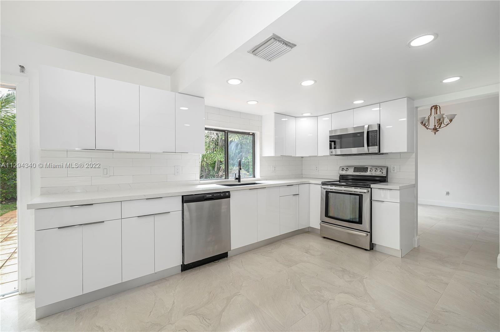 14442 Southwest 111th Street Miami, FL 33186 - Photo 7 of 15 a kitchen with granite countertop white cabinets and stainless steel appliances