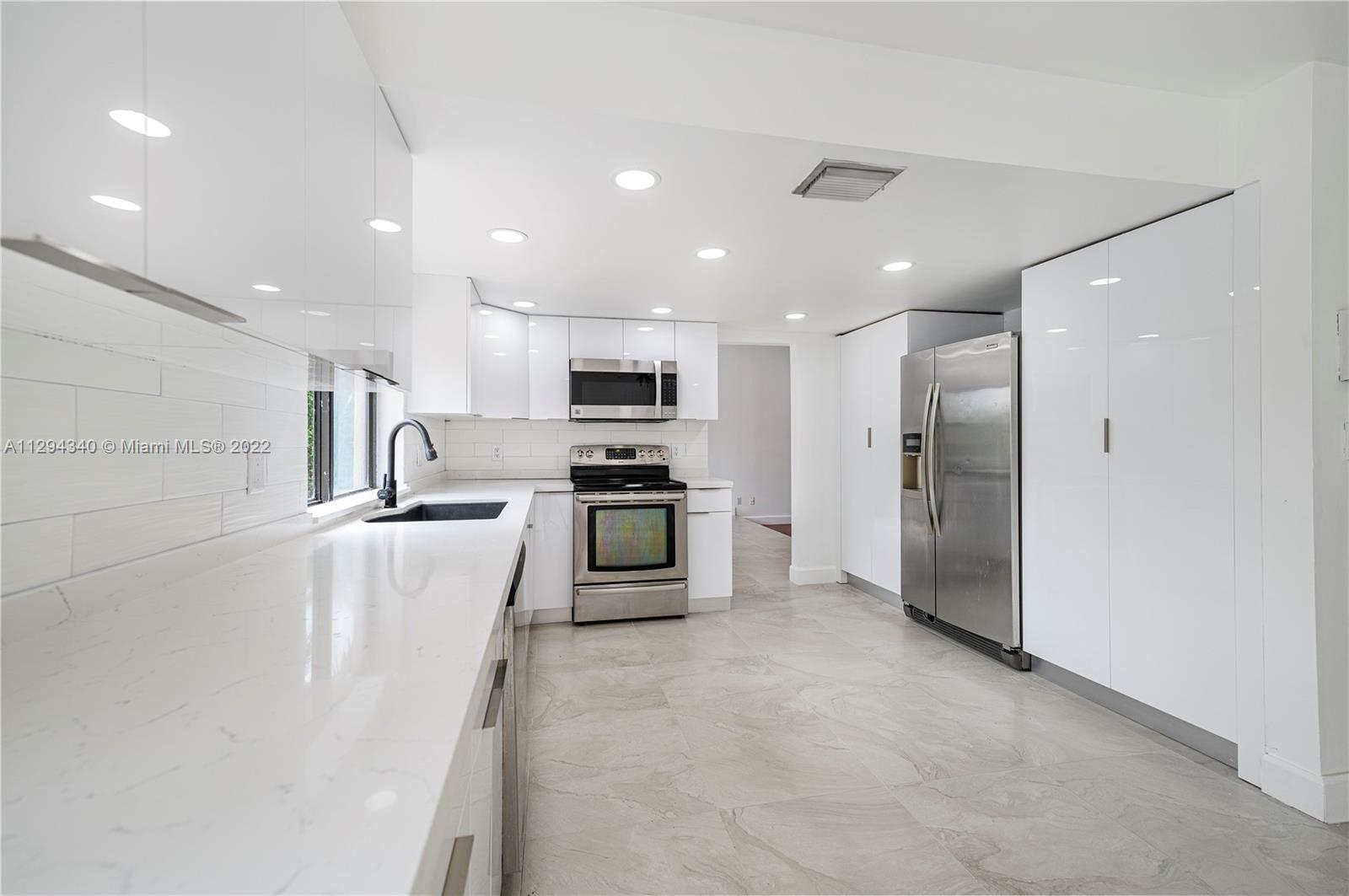14442 Southwest 111th Street Miami, FL 33186 - Photo 8 of 15 a kitchen with stainless steel appliances kitchen island sink refrigerator and microwave