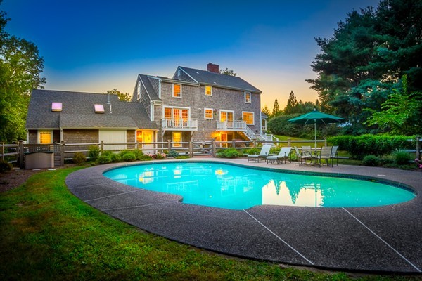 a view of an house with swimming pool and yard