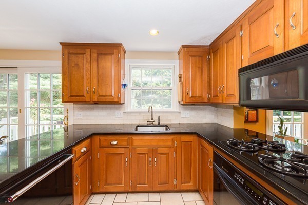 131 River Road Topsfield, MA 01983 - Photo 7 of 30 a kitchen with stainless steel appliances wooden cabinets and a stove top oven