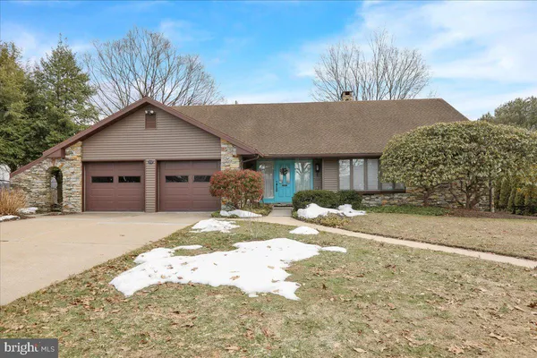 a front view of a house with a yard covered in snow
