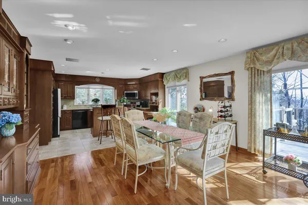 a open kitchen with stainless steel appliances granite countertop a stove top oven a sink dishwasher and cabinets with wooden floor