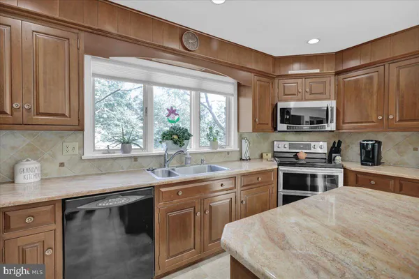 a kitchen with stainless steel appliances granite countertop a refrigerator and a sink