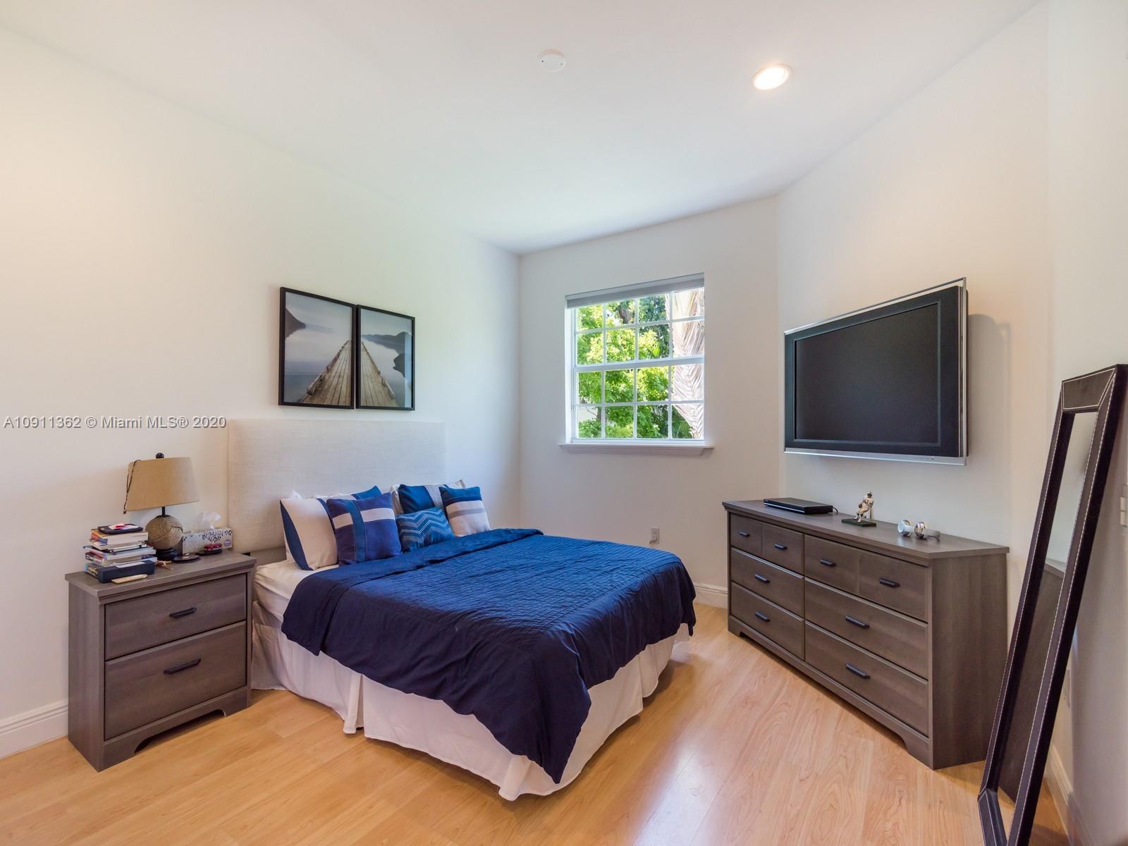 325 Pacific Road Key Biscayne, FL 33149 - Photo 11 of 31 a bedroom with a bed and a flat screen tv