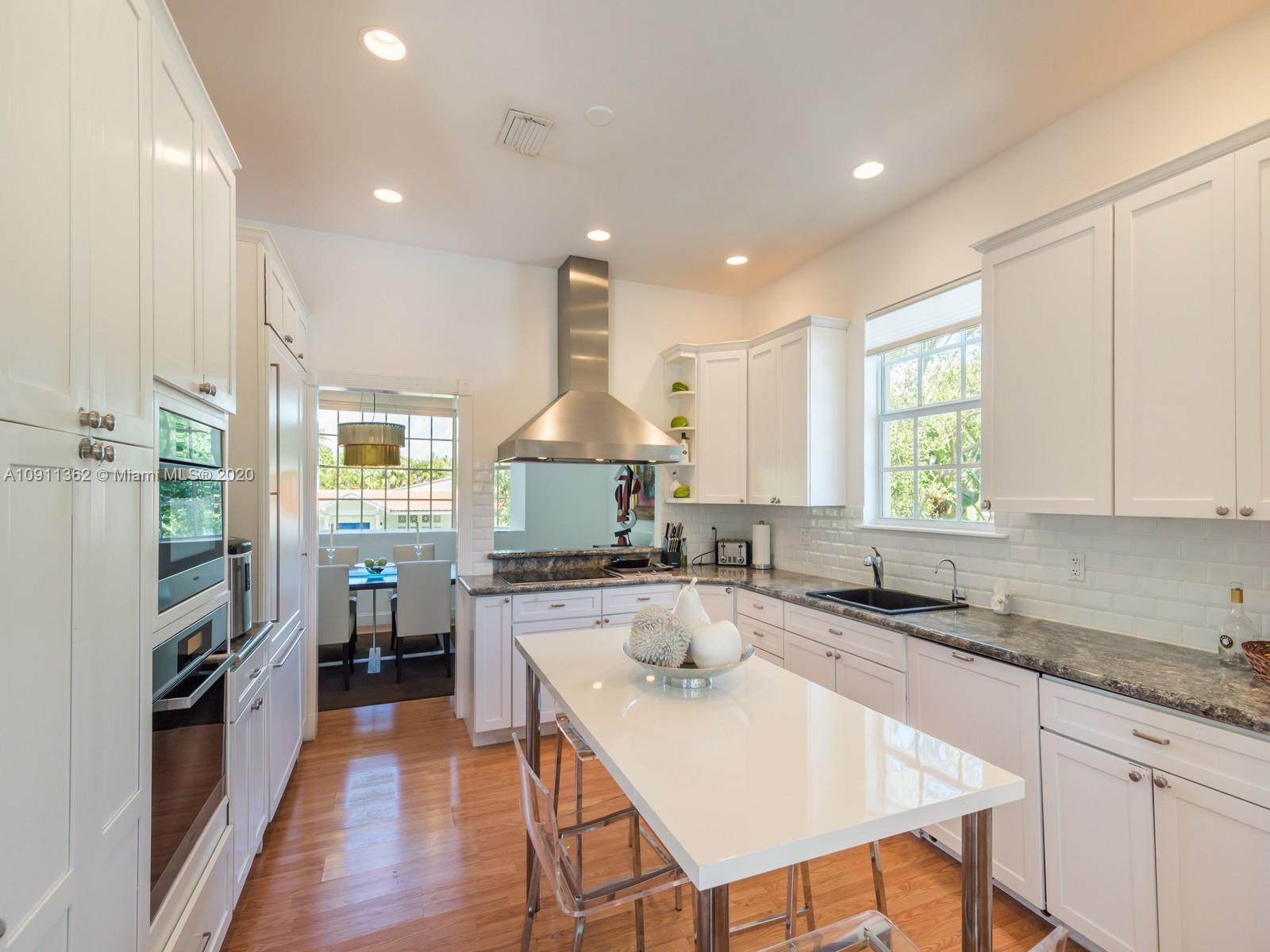325 Pacific Road Key Biscayne, FL 33149 - Photo 14 of 31 a kitchen with stainless steel appliances granite countertop a sink stove and refrigerator