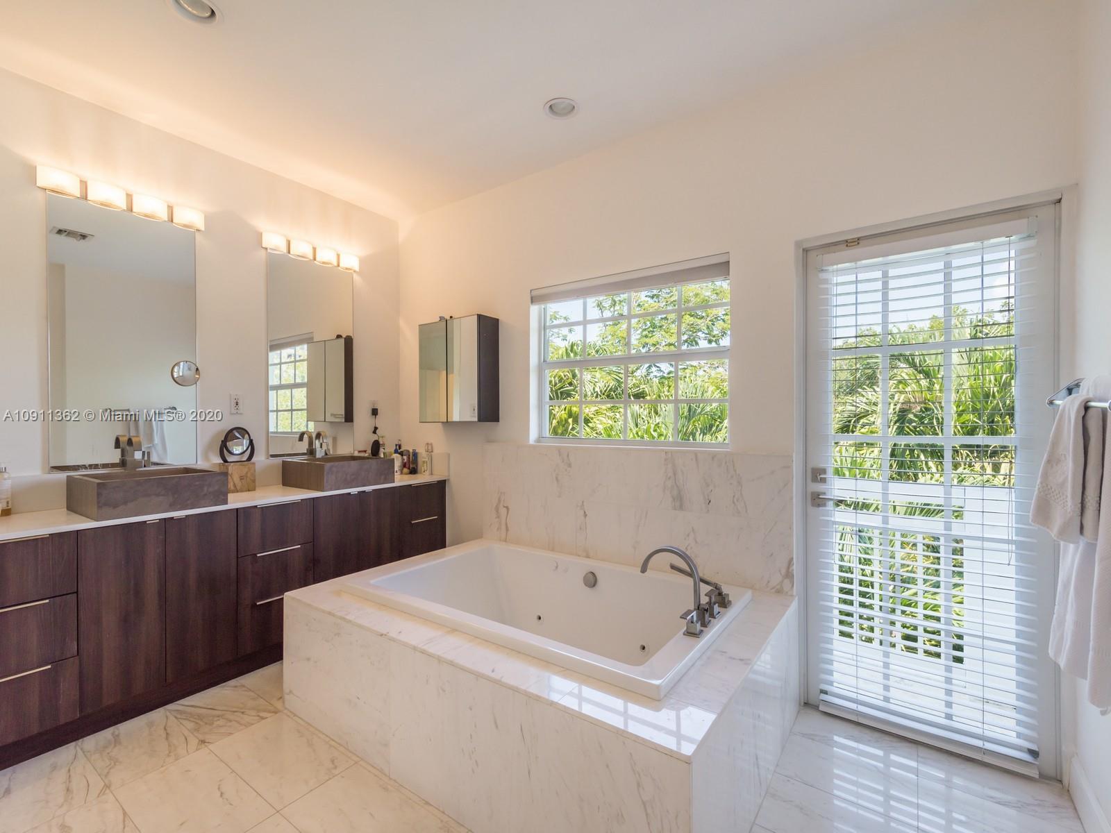 325 Pacific Road Key Biscayne, FL 33149 - Photo 19 of 31 a bathroom with a tub a sink and mirror