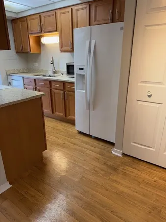 a kitchen with stainless steel appliances a refrigerator and wooden cabinets