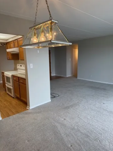 a view of a hallway with wooden floor and a bathroom