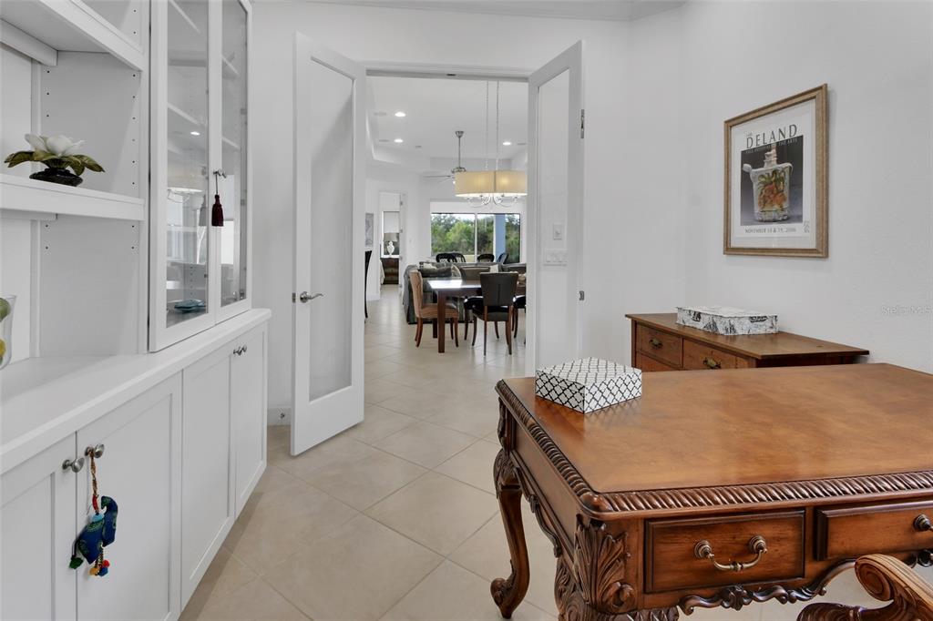 308 Locksley Court Deland, FL 32724 - Photo 12 of 56 a living room with furniture a dining table and a chandelier