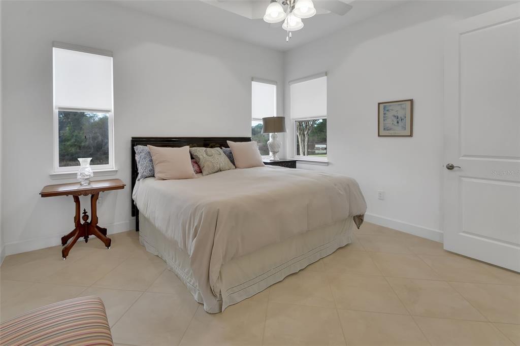 308 Locksley Court Deland, FL 32724 - Photo 14 of 56 a bedroom with a bed a chandelier and mirror