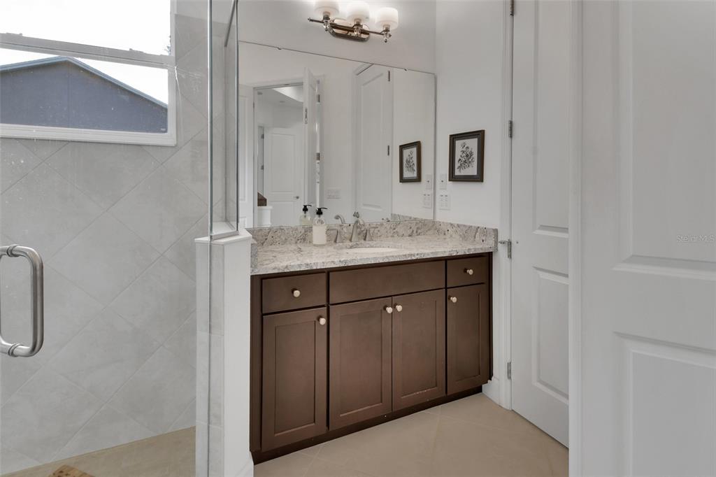 308 Locksley Court Deland, FL 32724 - Photo 17 of 56 a spacious bathroom with a granite countertop sink and a mirror