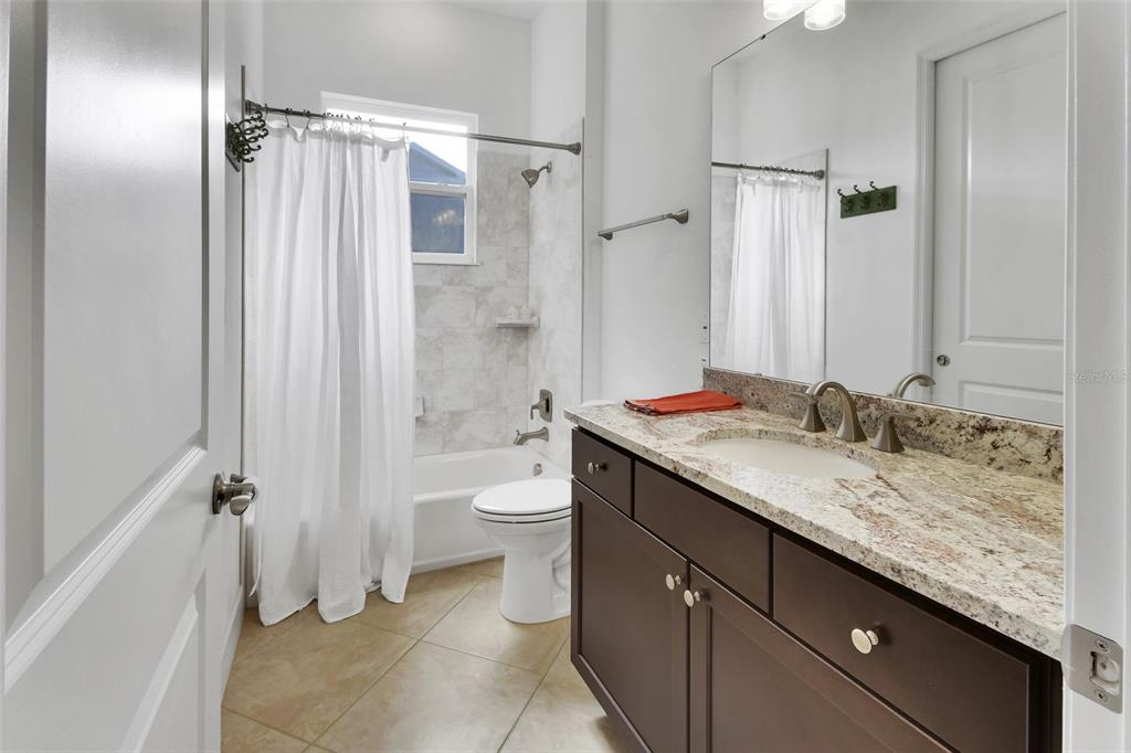 308 Locksley Court Deland, FL 32724 - Photo 23 of 56 a bathroom with a granite countertop sink toilet and shower