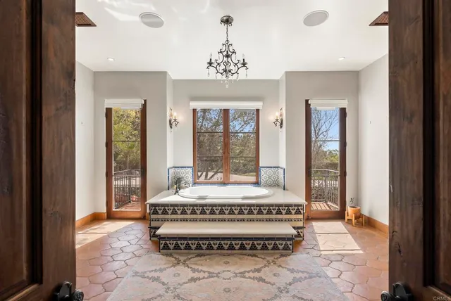 a spacious bedroom with a large bed and a chandelier