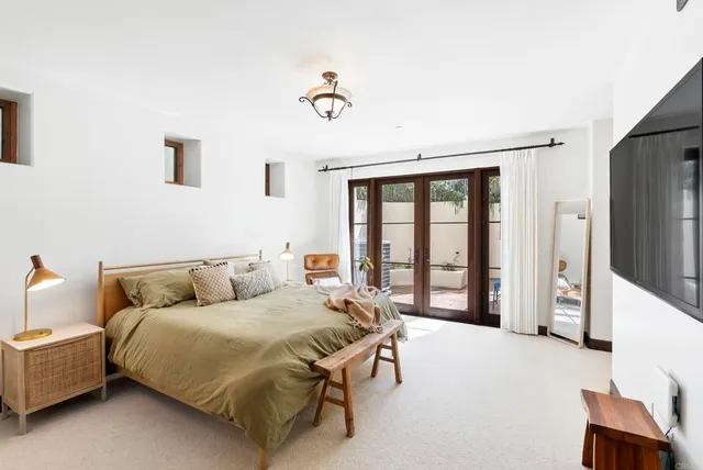 a bedroom with a bed and a large window