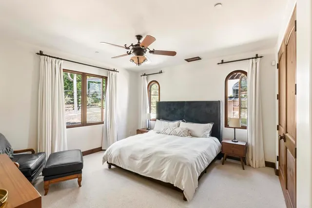 a bedroom with a bed ceiling fan and a window
