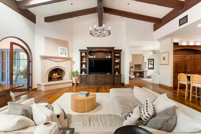 a living room with furniture a fireplace and a chandelier