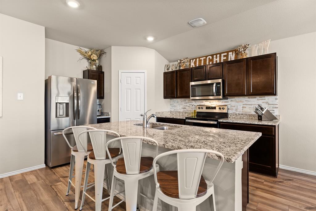 7209 Canadian Drive China Spring, TX 76633 - Photo 11 of 37 a kitchen with stainless steel appliances granite countertop a stove top oven a refrigerator a sink and a microwave