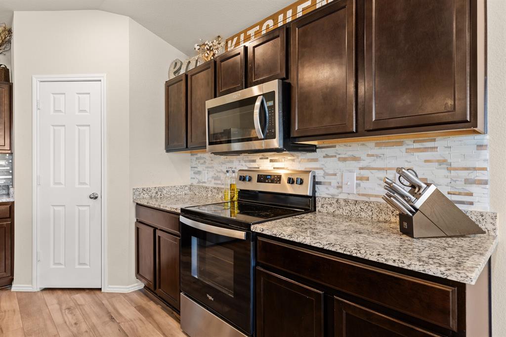 7209 Canadian Drive China Spring, TX 76633 - Photo 12 of 37 a kitchen with granite countertop cabinets stainless steel appliances and wooden floor
