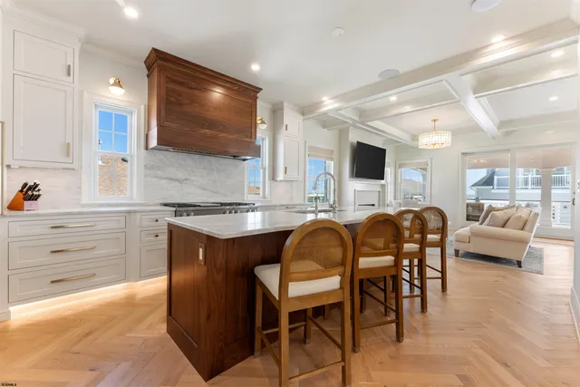 a kitchen with stainless steel appliances granite countertop a table chairs sink and window