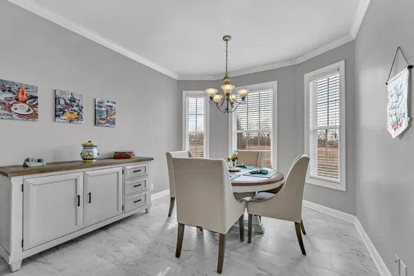 a dining room with furniture a chandelier and window