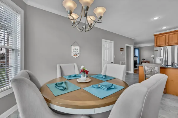 a view of a dining room with furniture a chandelier and wooden floor