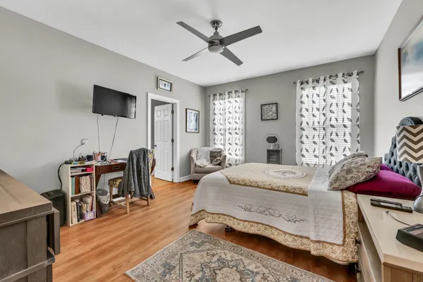 a bedroom with a bed and a table in it with wooden floor
