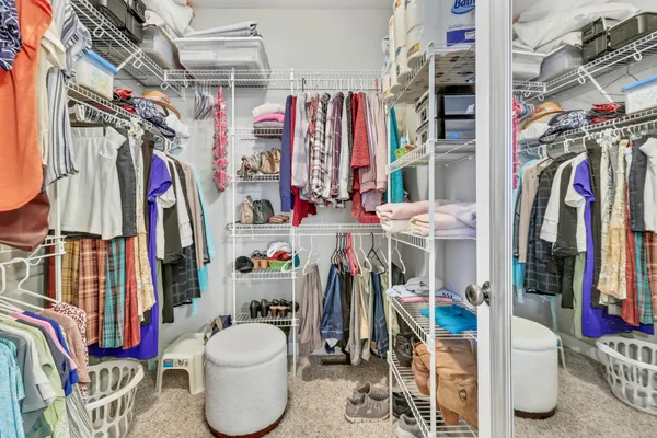 a view of walk in closet with clothes