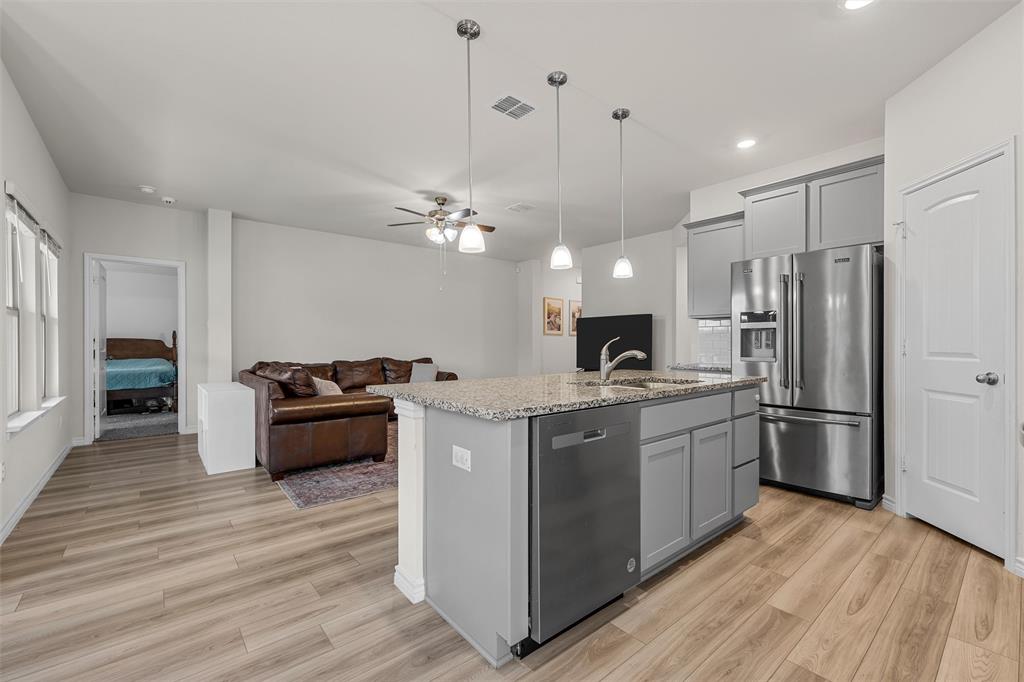 10712 Peperak Court Waco, TX 76708 - Photo 11 of 25 a kitchen with stainless steel appliances granite countertop a refrigerator a stove top oven a sink dishwasher and wooden floor