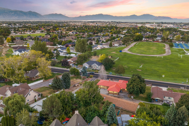875 Cedar Hollow Road Lehi, UT 84043 - Photo 22 of 76 Expansive suburban landscape featuring a prominent red-roofed structure, surrounded by mature trees, a green athletic field, and distant mountains