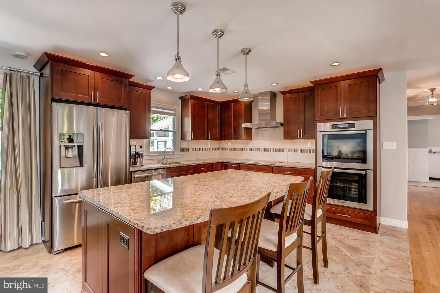 14202 Sunburst Road Baldwin, MD 21013 - Photo 8 of 29 a kitchen with a table chairs refrigerator and microwave