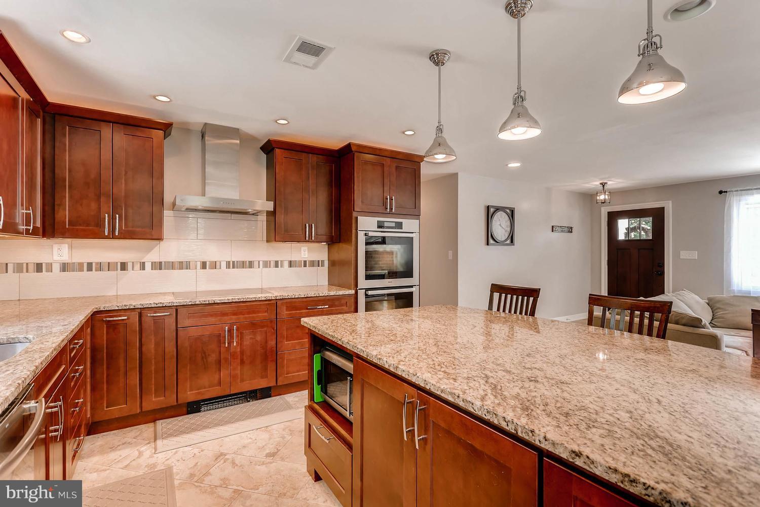 14202 Sunburst Road Baldwin, MD 21013 - Photo 9 of 29 a kitchen with stainless steel appliances granite countertop a sink a stove counter space and cabinets