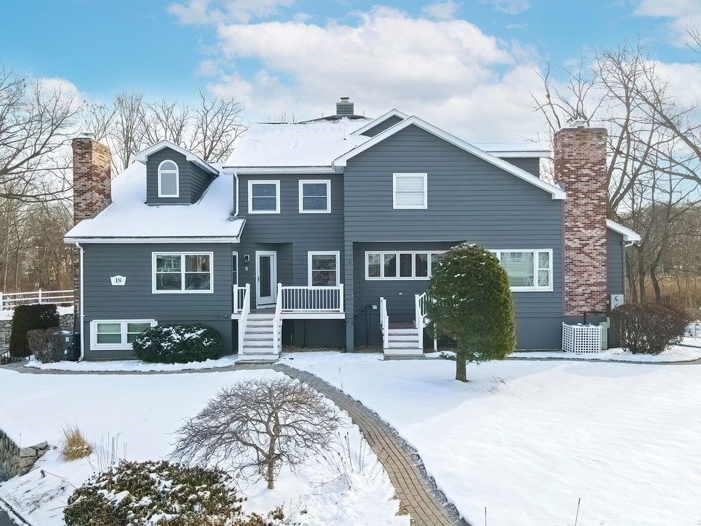 18 Carnation Circle, Unit B Reading, MA 01867 - Photo 2 of 42 a front view of a house with a yard covered with snow