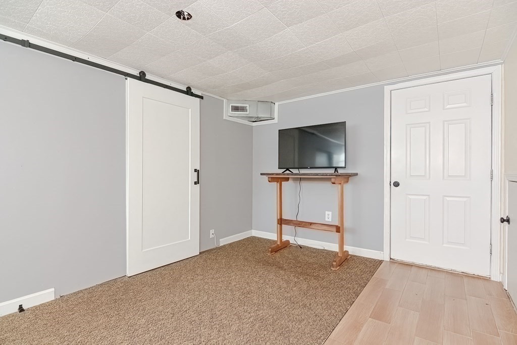 18 Carnation Circle, Unit B Reading, MA 01867 - Photo 36 of 42 a living room with a flat screen tv a rug and a flat screen tv