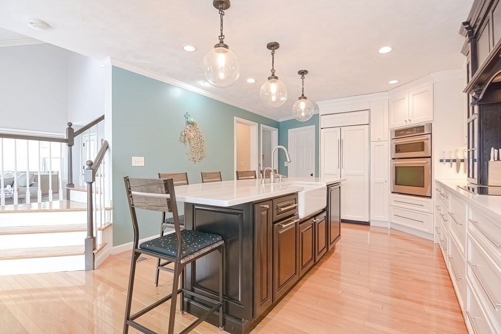 18 Carnation Circle, Unit B Reading, MA 01867 - Photo 8 of 42 a kitchen with stainless steel appliances granite countertop a kitchen island a stove and a sink