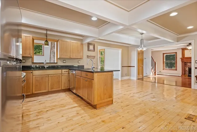 a large kitchen with cabinets a sink a counter top space and stainless steel appliances