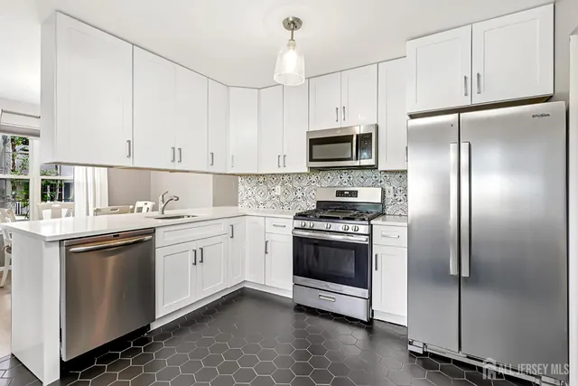 a kitchen with stainless steel appliances granite countertop a stove a sink and a refrigerator
