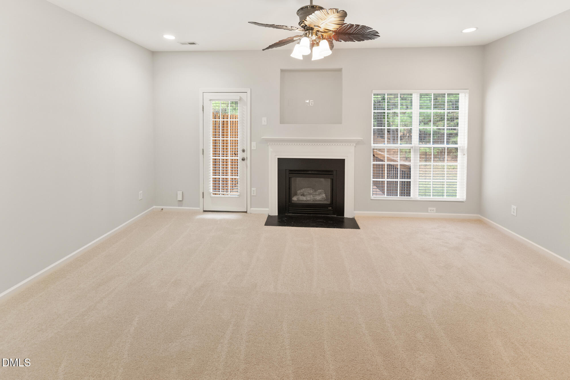 3123 Winding Waters Way Raleigh, NC 27614 - Photo 13 of 57 an empty room with a fireplace fan and windows