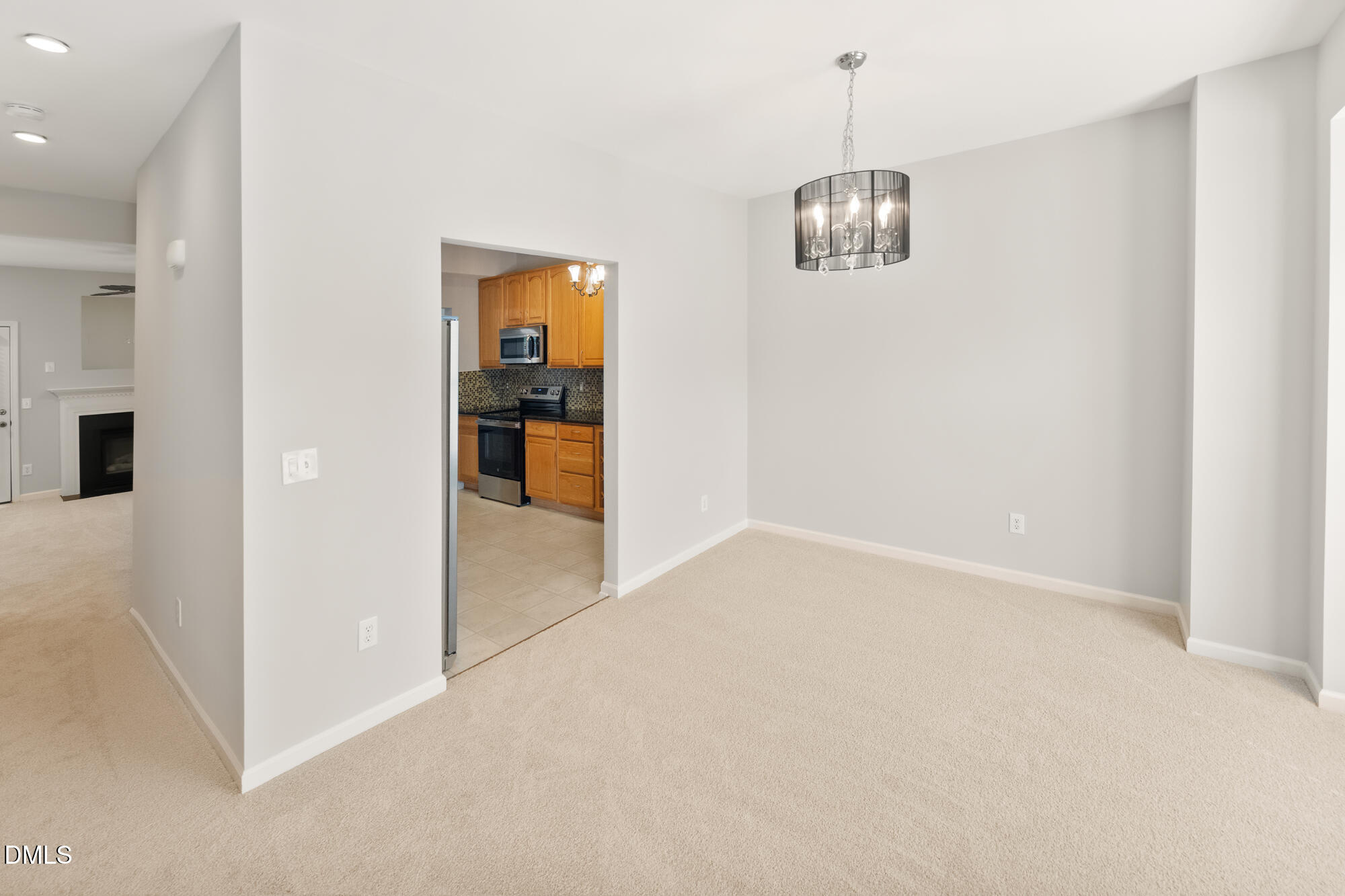 3123 Winding Waters Way Raleigh, NC 27614 - Photo 18 of 57 en empty room with chandelier fan and kitchen view