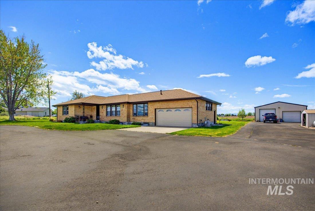 1901 South Ten Mile Road Meridian, ID 83642 - Photo 1 of 32 Brick exterior residence featuring a two-car garage with a large paved driveway